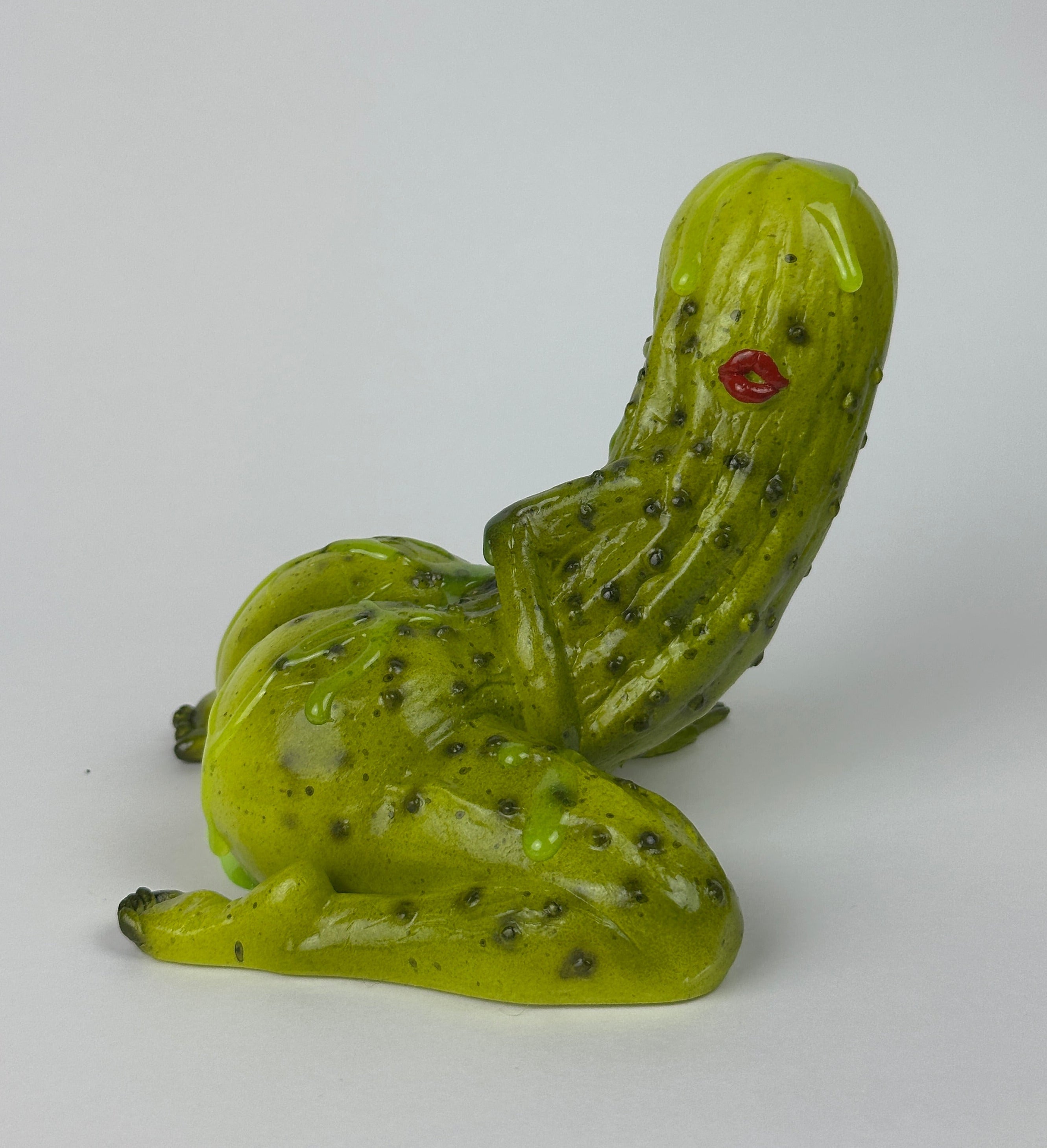 Pickle figurine with red lips on a white background